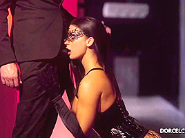 Gorgeous, black haired woman is wearing a lacy mask on her face while sucking a fat dick