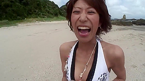 Randy brunette sucks guy's pole on the beach