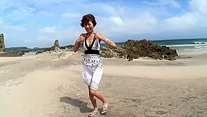 Randy brunette sucks guy's pole on the beach