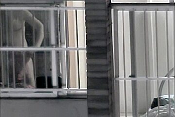 Sexy naked neighbor is staying in front of the open window