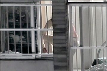 Sexy naked neighbor is staying in front of the open window