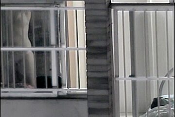 Sexy naked neighbor is staying in front of the open window